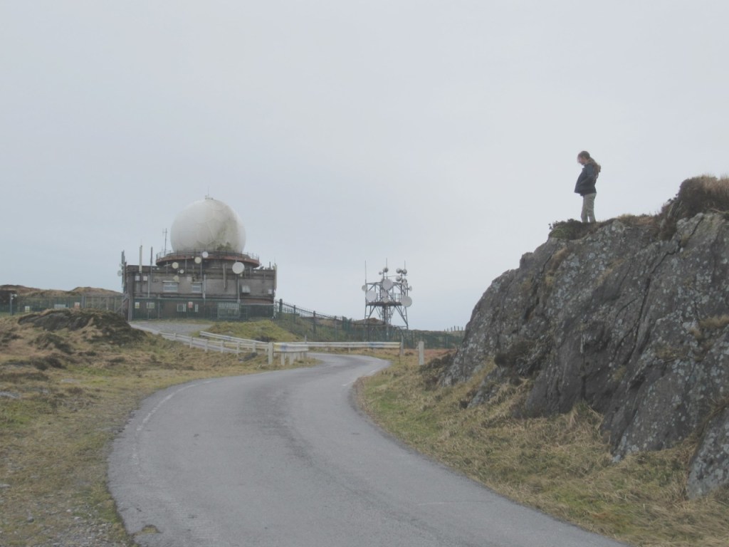 Child standing on rock near radar dome on mount gabriel